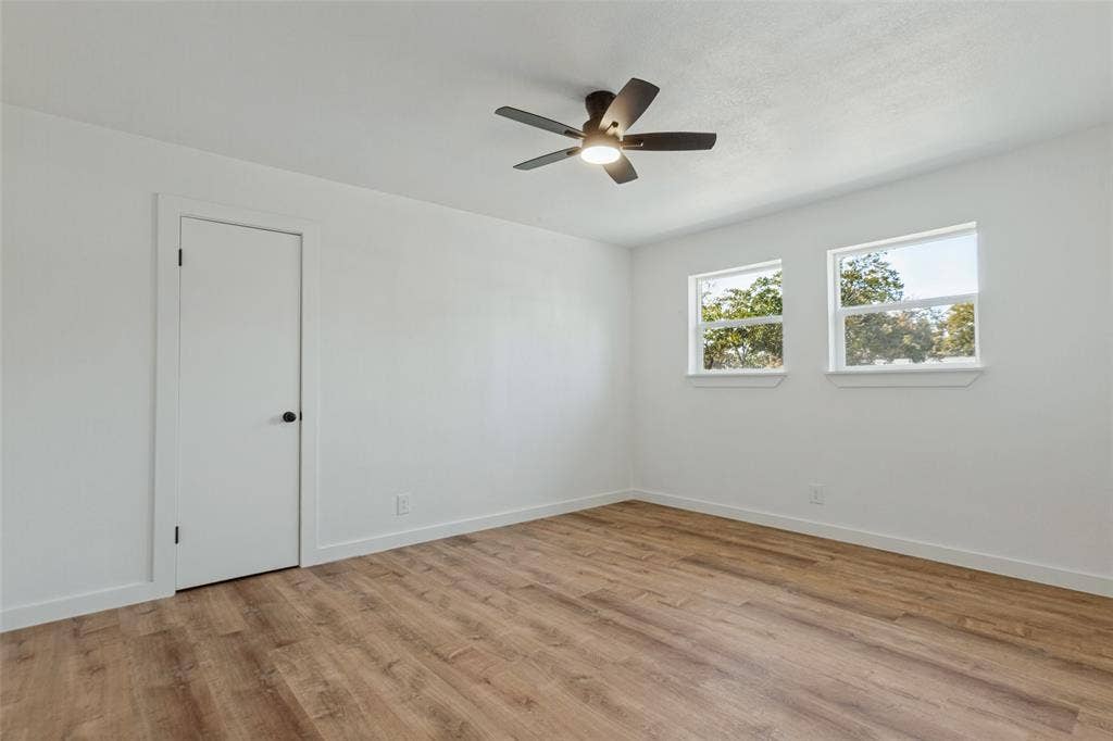 828 Melrose Drive, Richardson, TX 75234 Room featuring wood-finish flooring, dual windows, and a ceiling fan with integrated lighting