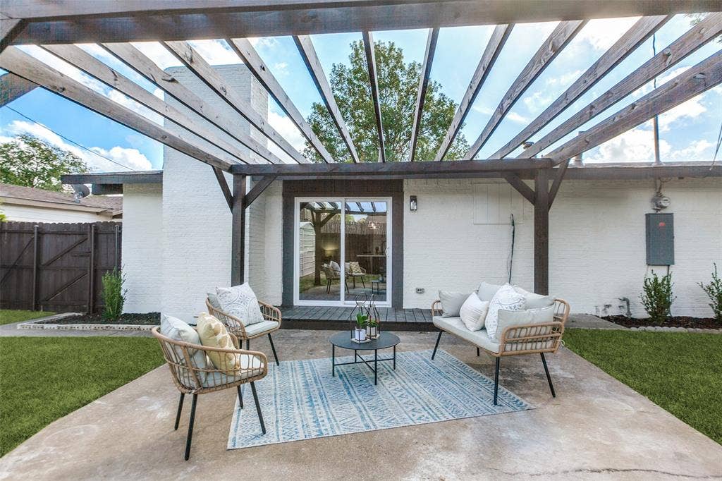 828 Melrose Drive, Richardson, TX 75234 Rear patio featuring a wooden pergola, concrete flooring, sliding glass door, and white brick exterior