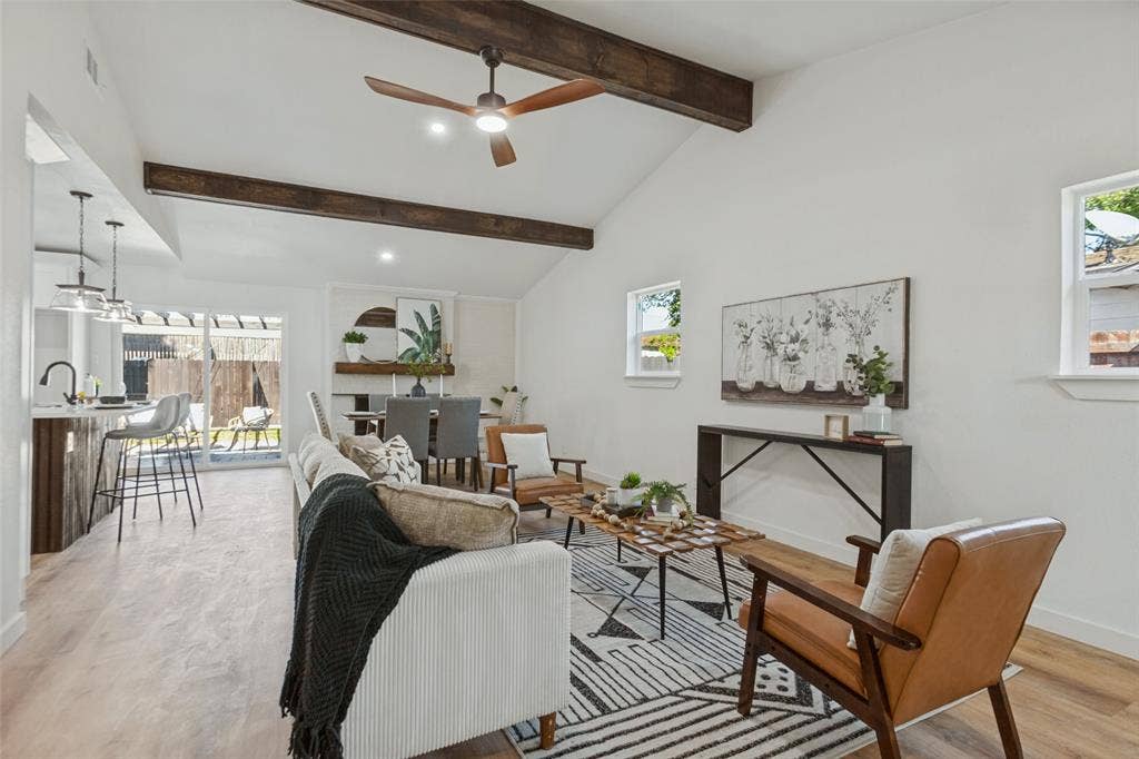 828 Melrose Drive, Richardson, TX 75234 Vaulted ceilings featuring stained wood beams, light-tone wood-finish flooring, and sliding glass doors with access to the outdoors