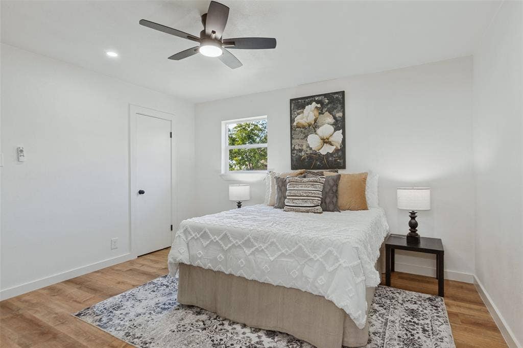 828 Melrose Drive, Richardson, TX 75234 Room featuring wood-finish flooring, a multi-blade ceiling fan with integrated lighting, and a single-panel interior door