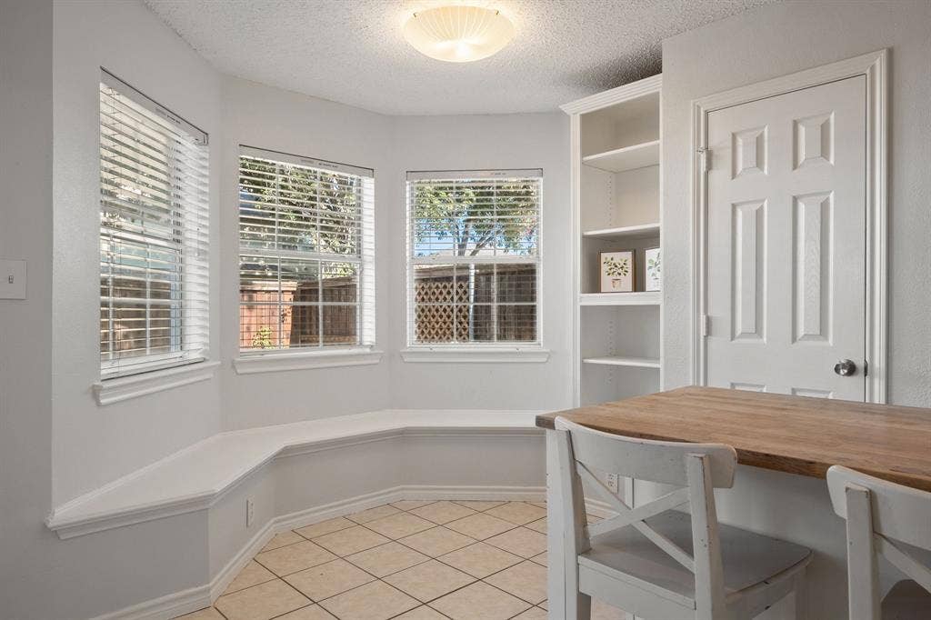 11414 Ocean Road, Frisco, TX 75035 Bay window featuring a built-in bench, ceramic tile flooring, built-in shelving, and dual-pane windows with horizontal blinds