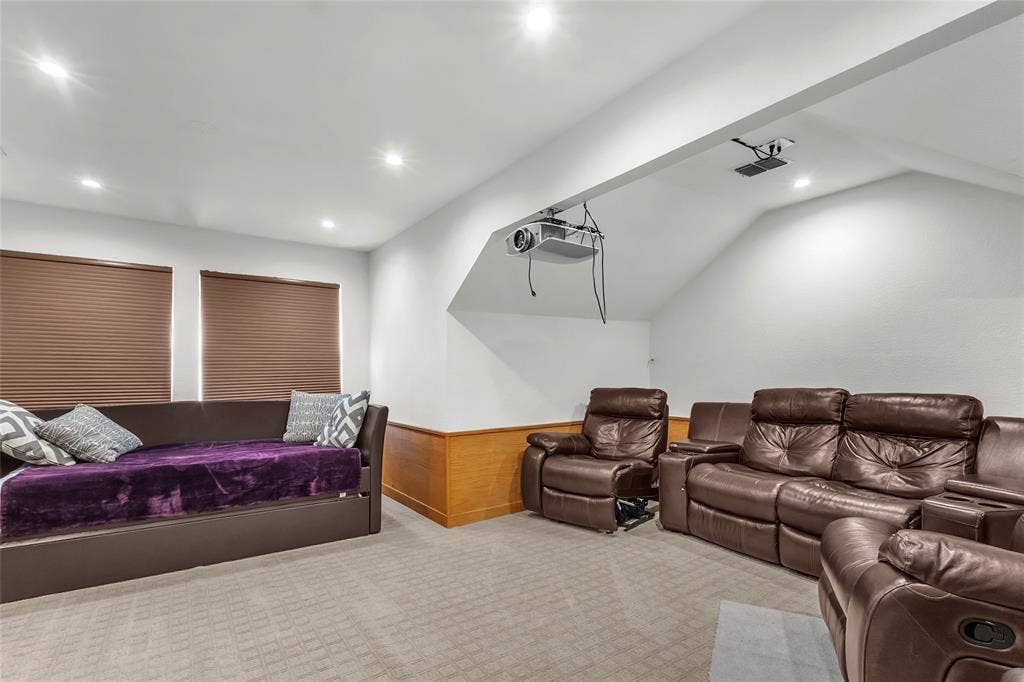Upstairs media room with carpet, angled ceilings, and two windows — 5804 Lafayette Dr, Frisco