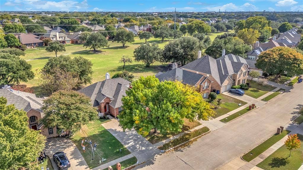 Aerial view of the home backing to the fairway with mature trees — 5804 Lafayette Dr, Frisco