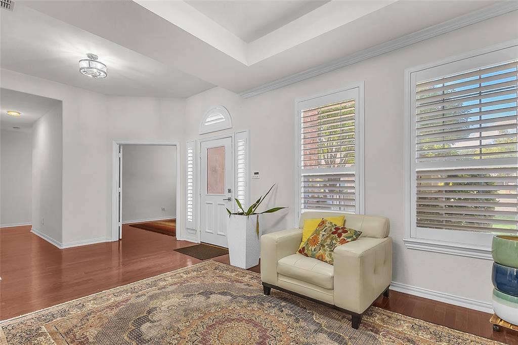 Entry and front room with tray ceiling and engineered hardwood floors — 5804 Lafayette Dr, Frisco