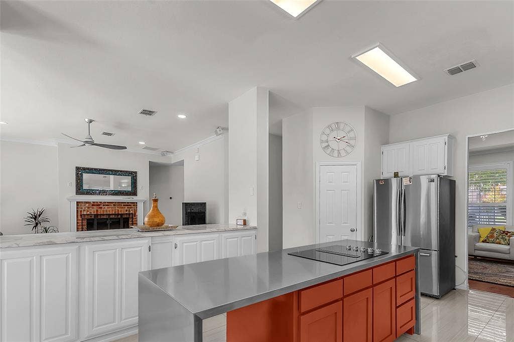 Kitchen with stainless-steel waterfall island and granite counters — 5804 Lafayette Dr, Frisco