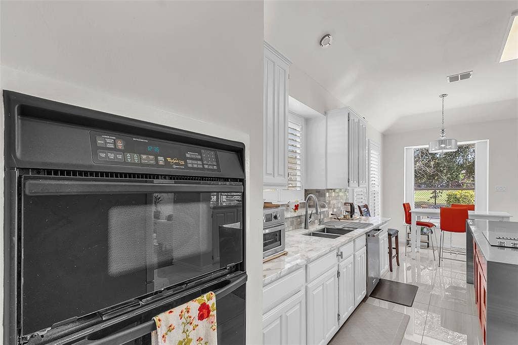 Kitchen with double wall oven, granite counters, and tile floors — 5804 Lafayette Dr, Frisco