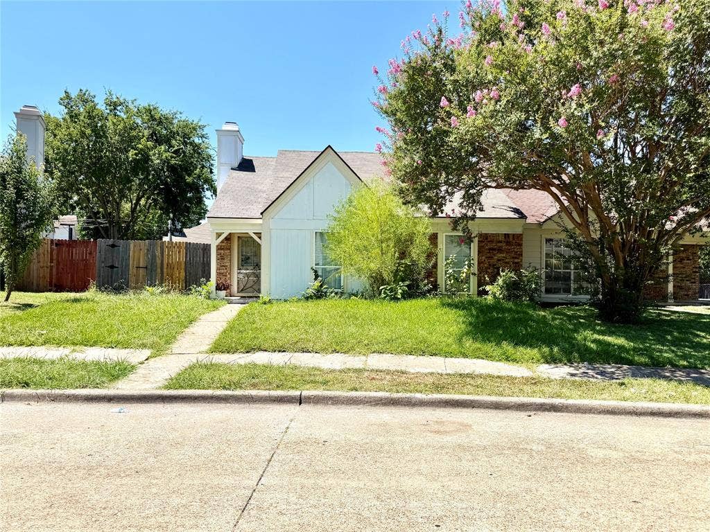 817 Colchester Drive, Mesquite, TX 75149 Exterior featuring a pitched roof, brick facade, white siding, and a prominent flowering tree
