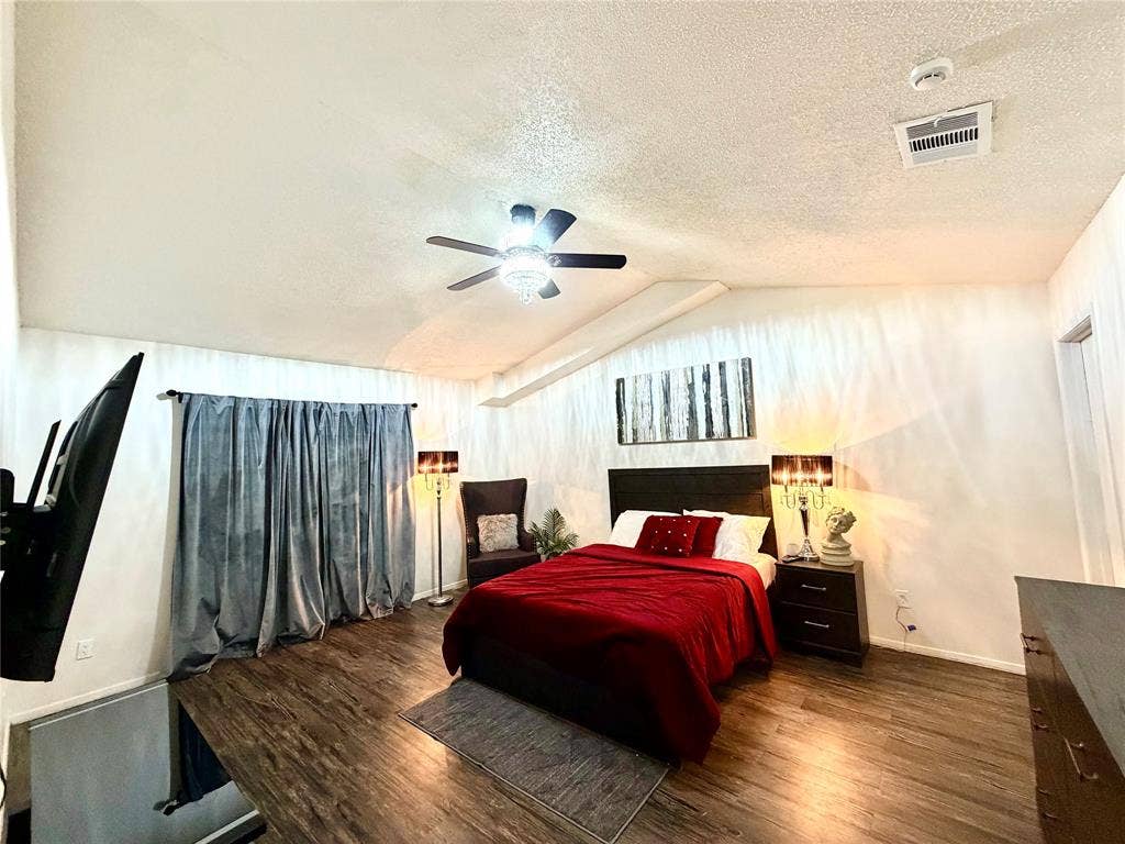 817 Colchester Drive, Mesquite, TX 75149 Spacious room featuring vaulted ceilings, wood-finish flooring, and a ceiling fan with integrated lighting