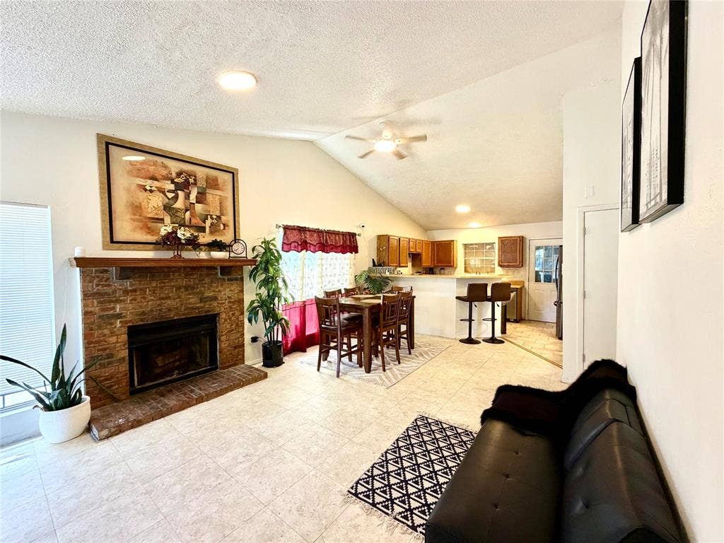 817 Colchester Drive, Mesquite, TX 75149 Living area featuring a brick fireplace with a wood mantle, vaulted ceilings, and recessed lighting