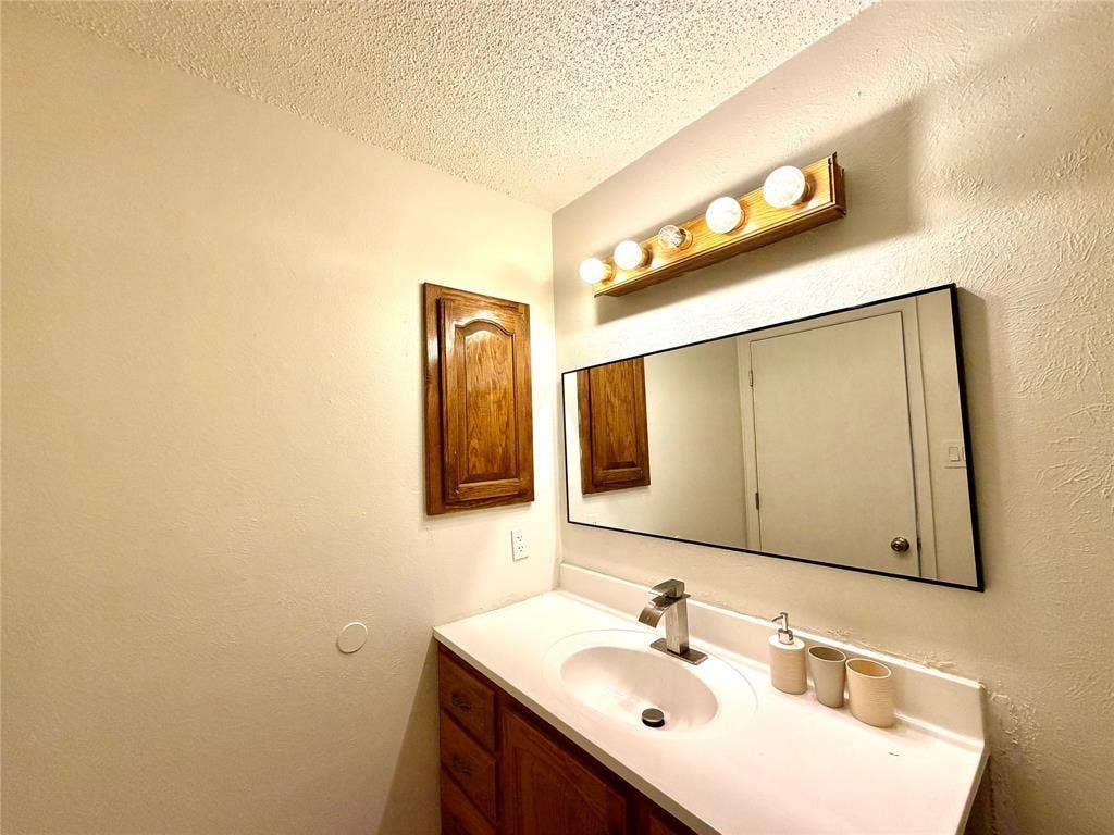 817 Colchester Drive, Mesquite, TX 75149 Bathroom vanity featuring a single basin sink, chrome faucet, and white countertop