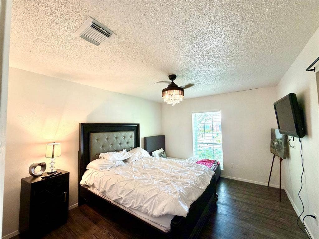 817 Colchester Drive, Mesquite, TX 75149 Bedroom featuring wood-finish flooring, a contemporary chandelier fan, a window with horizontal blinds, and textured ceilings