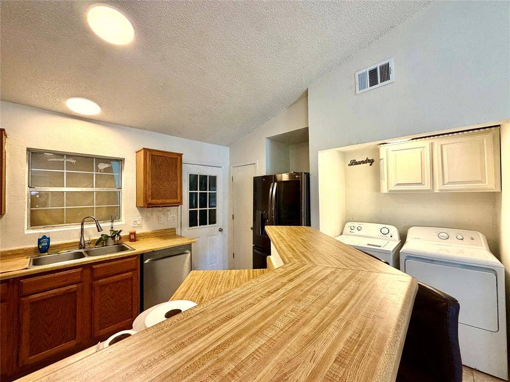 817 Colchester Drive, Mesquite, TX 75149 Kitchen area featuring a wood-finish countertop bar, stainless steel sink, wood cabinetry, and a full-light rear door