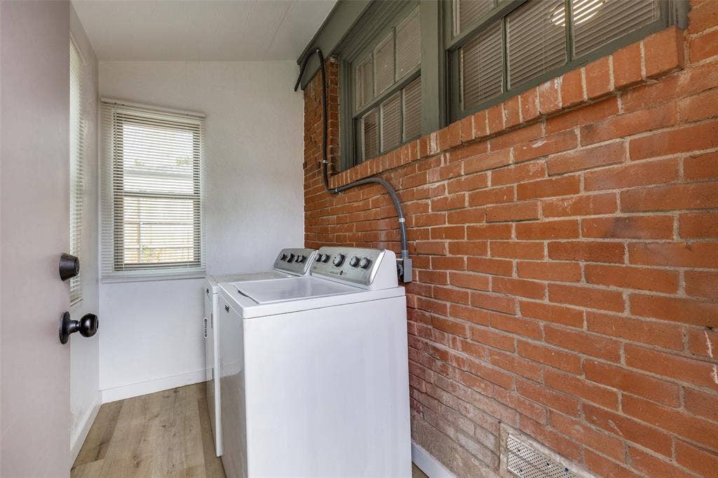 6719 Kenwell Street, Dallas, TX 75209 Exposed brick wall, multi-pane windows, wood-finish flooring, and white interior wall finishes