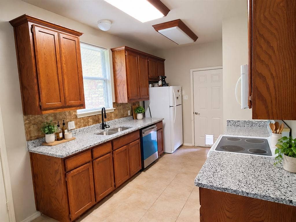 462 Pittman Street, Richardson, TX 75081 Kitchen featuring wood cabinetry, stone-finish countertops, tile backsplash, tile flooring, and integrated dishwasher