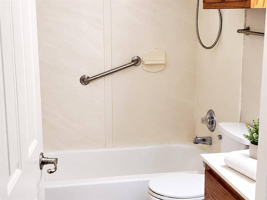462 Pittman Street, Richardson, TX 75081 Bathroom featuring a tub-shower combination with integrated wall surrounds, brushed metal grab bar, built-in soap dish, and a vanity with a white countertop