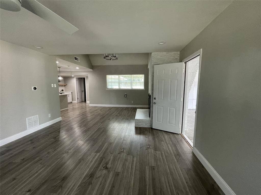 Unfurnished living room featuring dark wood-type flooring