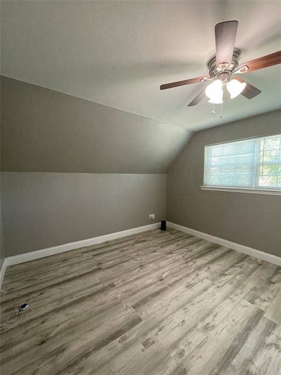 Additional living space featuring vaulted ceiling, ceiling fan, and hardwood / wood-style floors