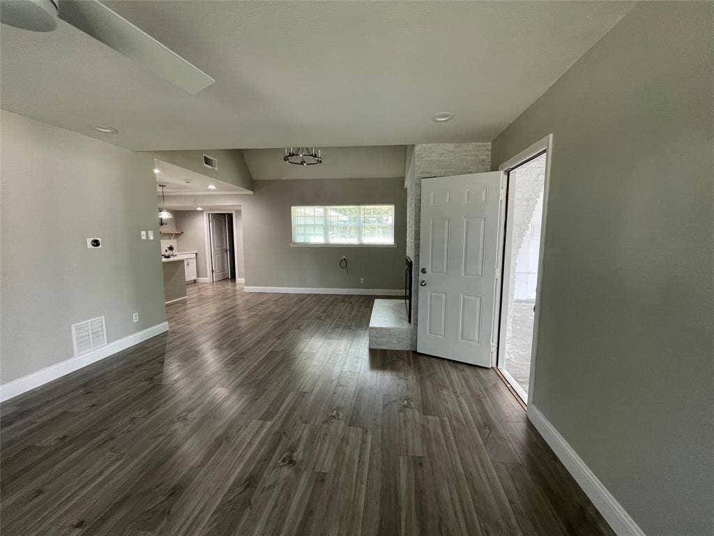 Unfurnished living room featuring dark hardwood / wood-style flooring