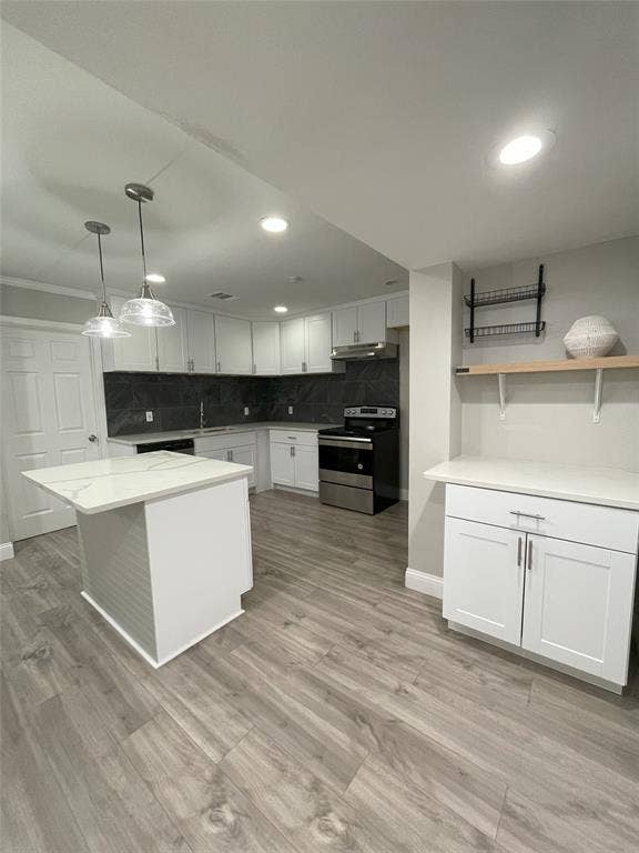 Kitchen featuring white cabinetry, decorative backsplash, sink, stainless steel range with electric stovetop, and light hardwood / wood-style flooring