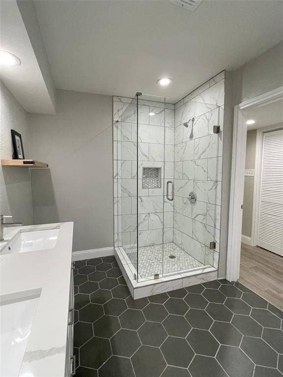 Bathroom with walk in shower, hardwood / wood-style flooring, and dual vanity