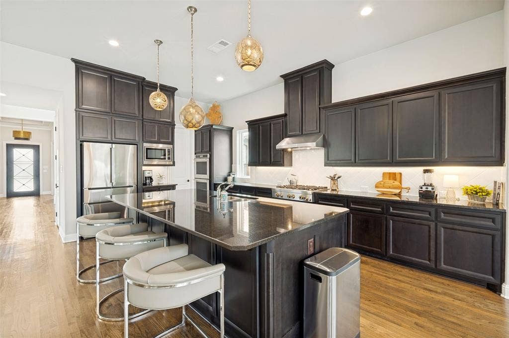 1730 Cottonwood Trail, Prosper, TX 75078 The rich cabinetry is is spacious and features dimmable under cabinet lighting and ample storage.
