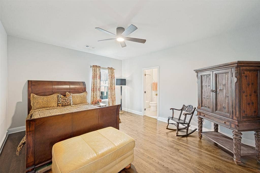 1730 Cottonwood Trail, Prosper, TX 75078 Upstairs spacious bedroom featuring wood-finish flooring, a ceiling fan with integrated lighting, and a private ensuite.