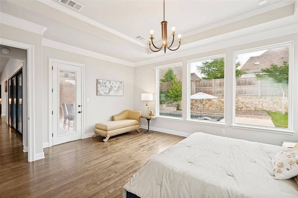 1730 Cottonwood Trail, Prosper, TX 75078 The spacious primary suite provides space for a sitting area and direct access to the patio along with expansive windows overlooking the private backyard and pool