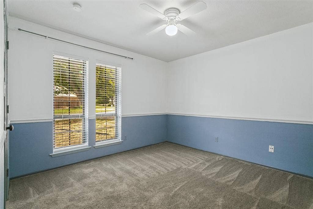 8820 Woodstream Drive, Frisco, TX 75034 Neutral wall palette with chair rail molding, dual-pane windows, and ceiling fan with integrated lighting