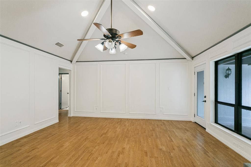 8820 Woodstream Drive, Frisco, TX 75034 Vaulted ceiling featuring exposed beams, wood-finish flooring, wainscoting wall detailing, and a multi-light ceiling fan