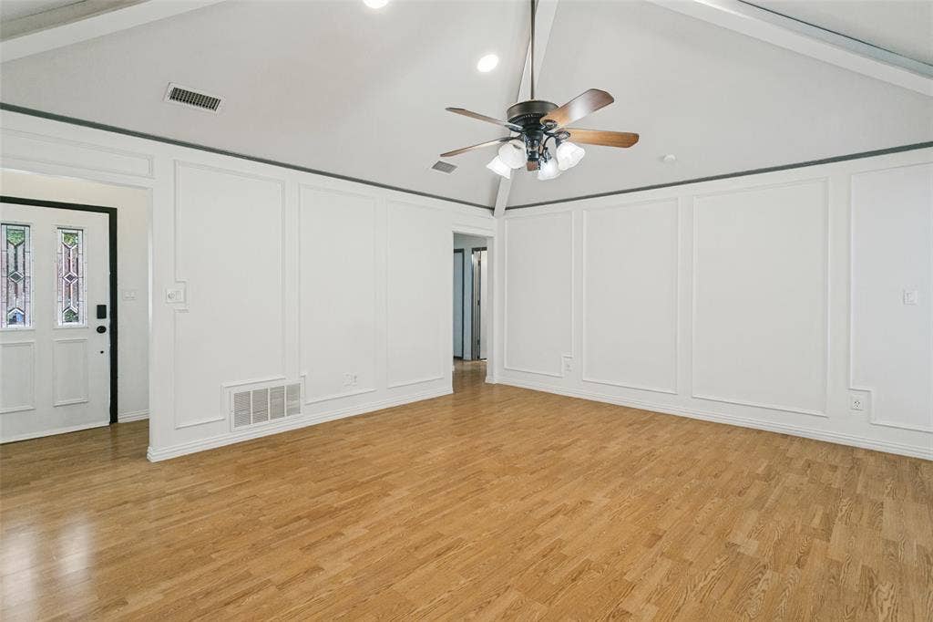8820 Woodstream Drive, Frisco, TX 75034 Vaulted ceilings, wainscoting wall paneling, wood-finish flooring, and a multi-lite glass entry door