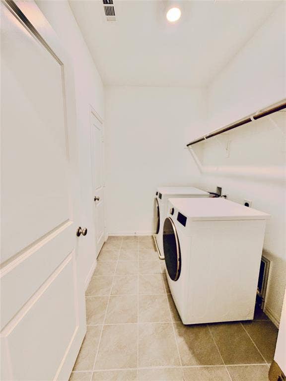 Laundry space featuring neutral ceramic tile flooring and a built-in wall-mounted shelving unit