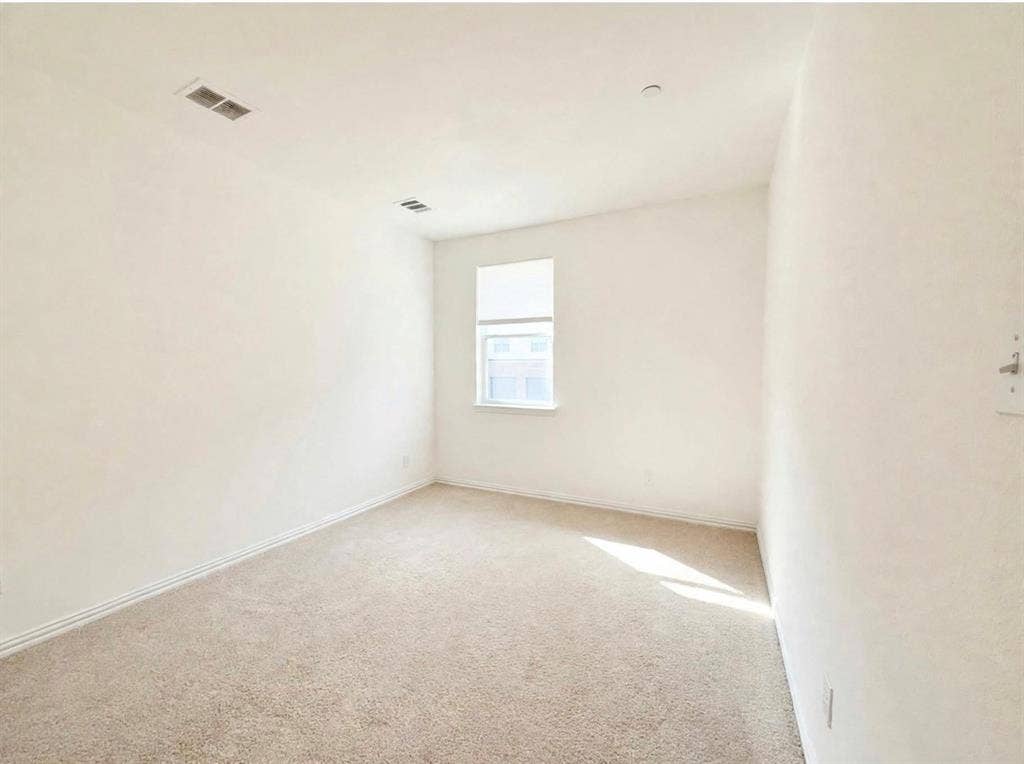 Interior space featuring neutral wall tones, carpeted flooring, and a single-pane window