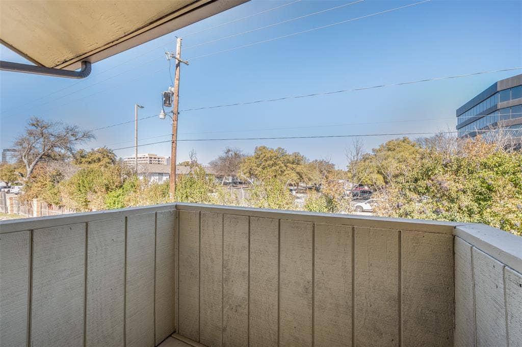 5623 Harvest Hill Road, #2023, Dallas, TX 75230 Covered balcony featuring vertical wood-paneled walls and an overhead overhang