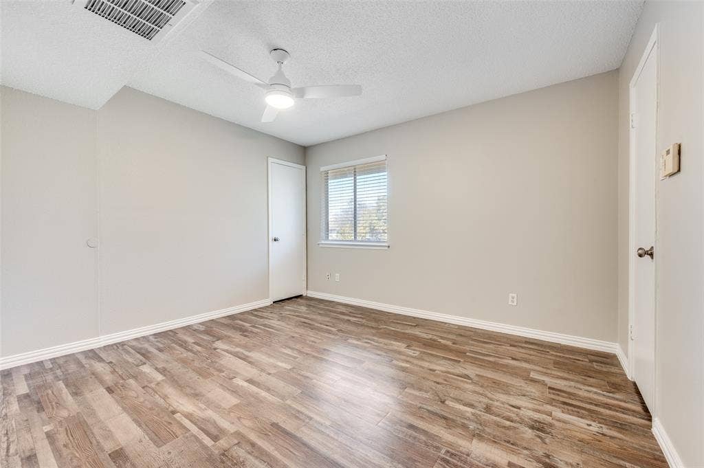 5623 Harvest Hill Road, #2023, Dallas, TX 75230 Room featuring Wood-look luxury vinyl planks (LVP) a white ceiling fan with integrated lighting, and a single window with horizontal blinds