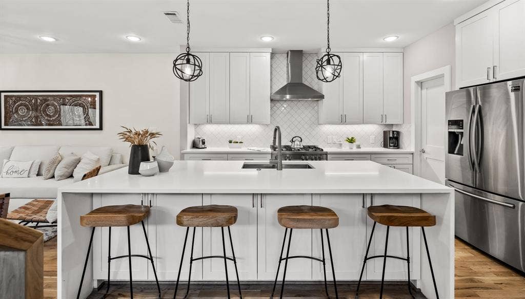406 Parkview Avenue, Dallas, TX 75223 Kitchen with wall chimney exhaust hood, a breakfast bar, hardwood / wood-style flooring, and stainless steel fridge with ice dispenser