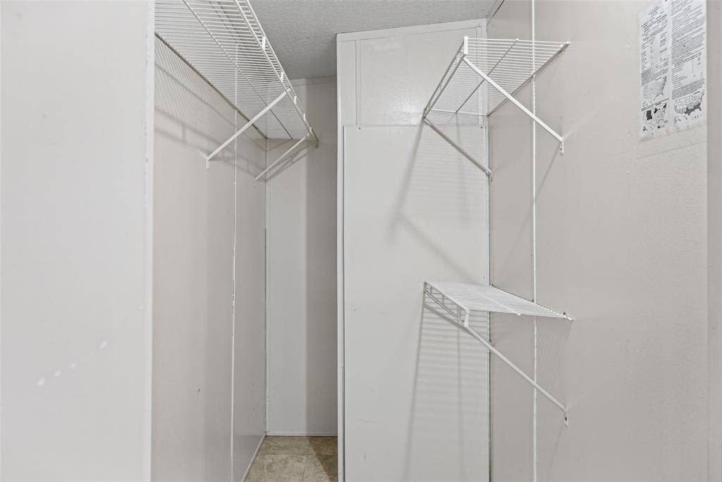 Storage space featuring white wall-mounted wire shelving units