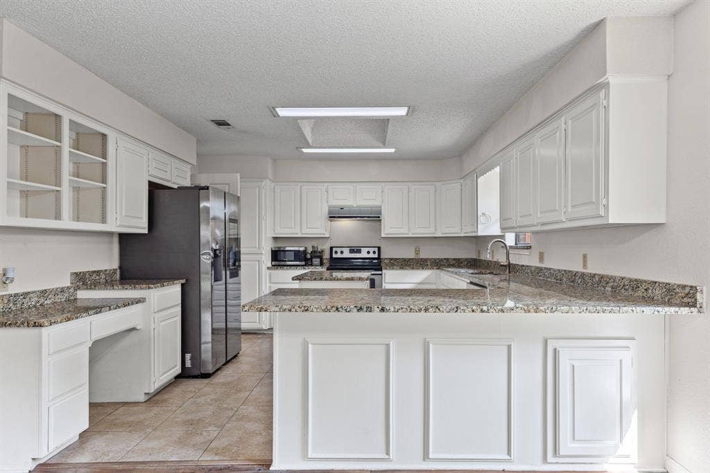 1307 Edna Street, Commerce, TX 75428 Kitchen featuring white cabinetry, stone-surface countertops, tile flooring, stainless steel side-by-side refrigerator, and recessed lighting