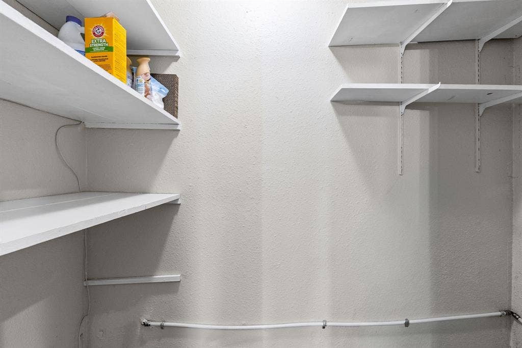 1307 Edna Street, Commerce, TX 75428 Storage space featuring white adjustable shelving units mounted on metal tracks