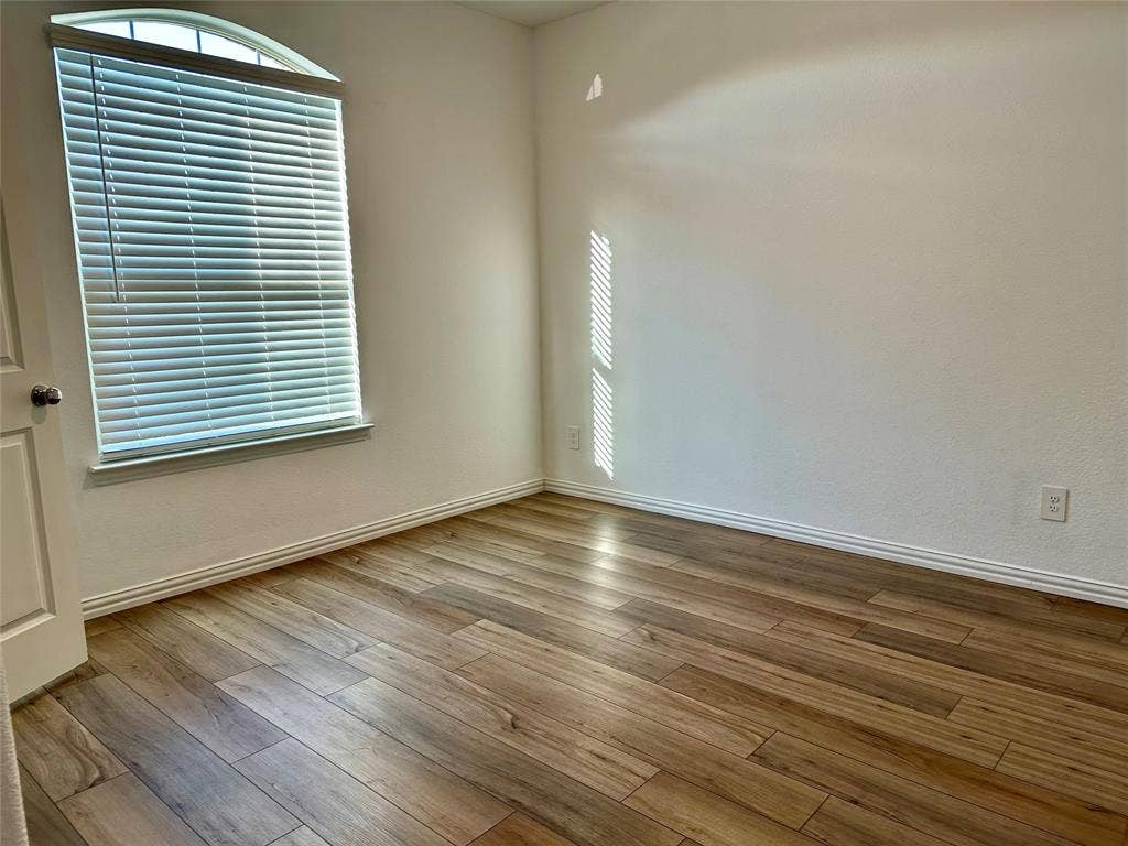 Entryway featuring wood-finish flooring, a solid black front door with a vertical frosted glass panel, and recessed ceiling lighting