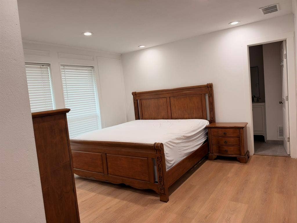 Room featuring wood-finish flooring, recessed lighting, and wall wainscoting