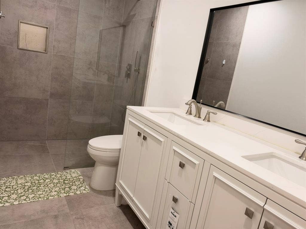 Double vanity with white cabinetry, quartz countertop, and integrated dual sinks featuring metallic fixtures
