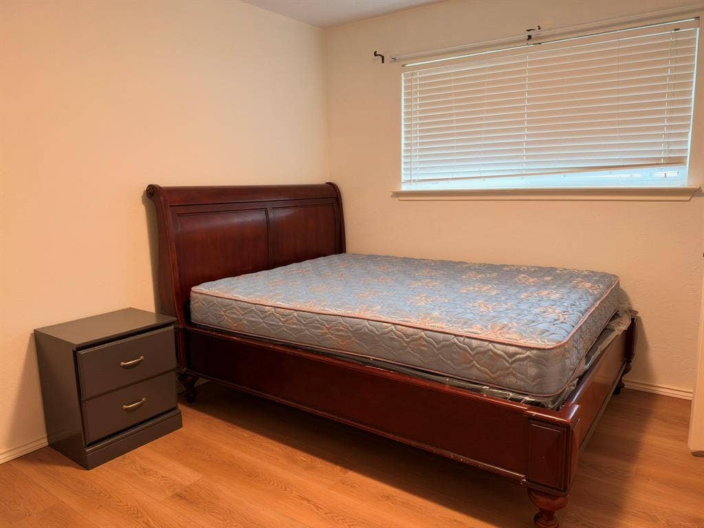 Room with wood-finish flooring and horizontal slat blinds
