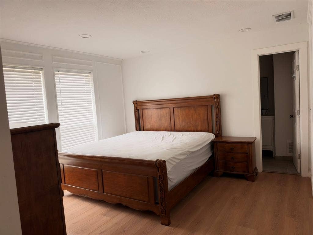 Interior room featuring wood-finish flooring, recessed lighting, and crisp white wall paneling with double-window configuration