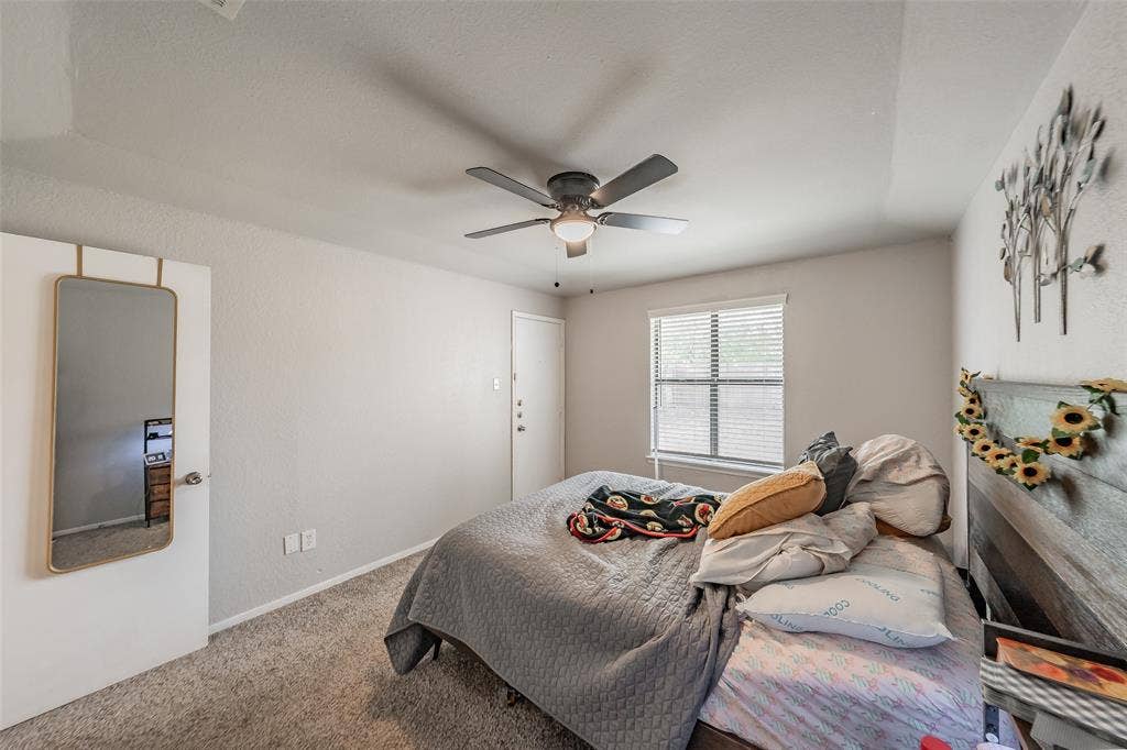1126 Neutral-toned bedroom featuring wall-to-wall carpeting, a ceiling fan with integrated lighting, and a single window with horizontal blinds