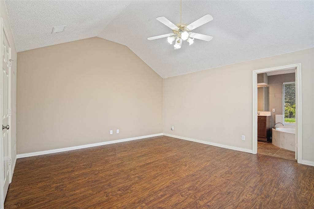 1909 Blackfoot Trail, Mesquite, TX 75149 Vaulted ceiling featuring a central multi-blade ceiling fan with integrated light fixture and wood-finish flooring