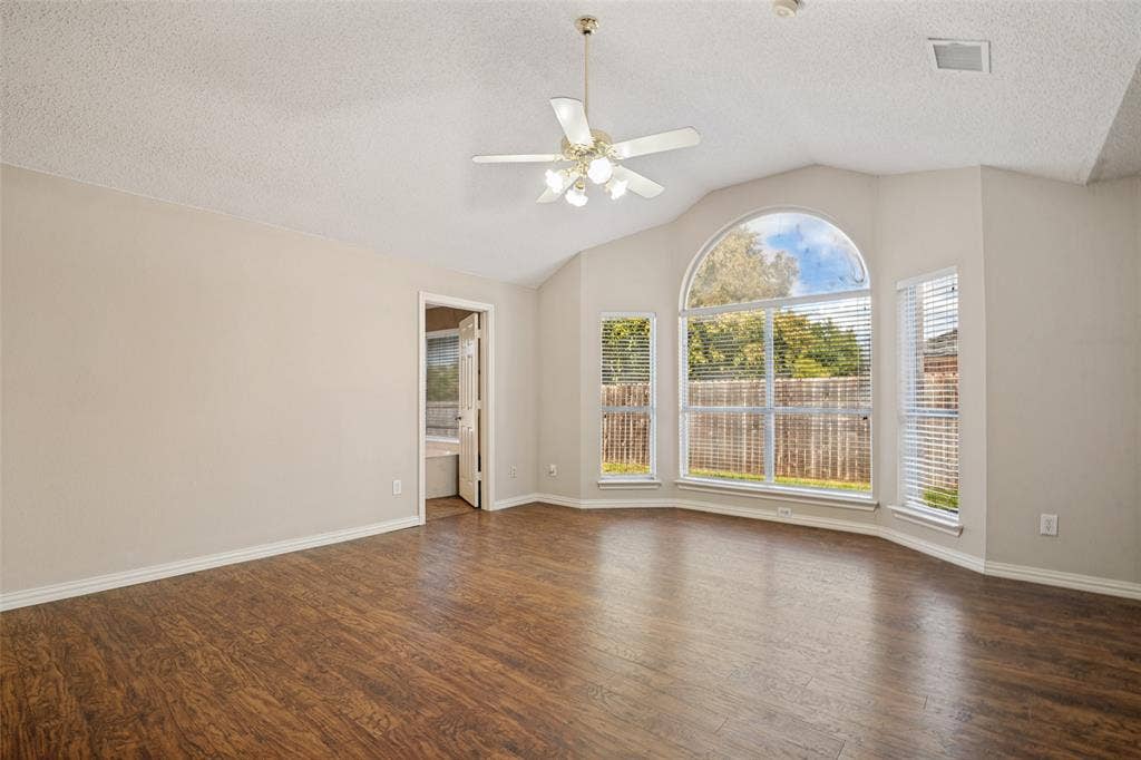 1909 Blackfoot Trail, Mesquite, TX 75149 Living area featuring vaulted ceilings, wood-finish flooring, an arched window, and a multi-light ceiling fan