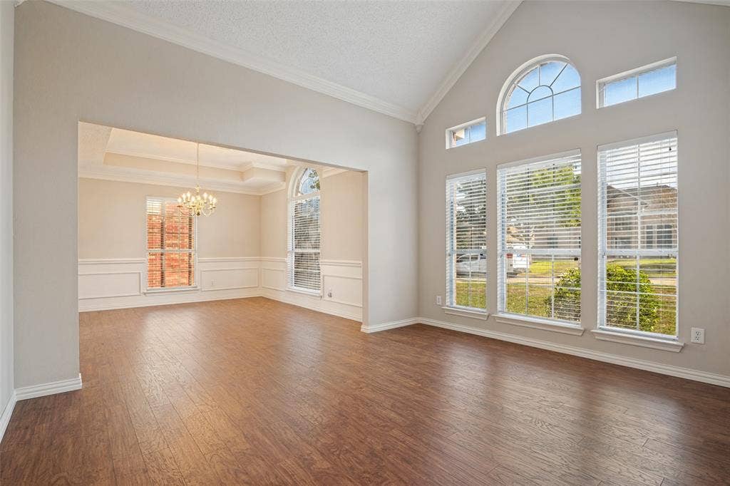 1909 Blackfoot Trail, Mesquite, TX 75149 Vaulted ceilings with crown molding, wood-finish flooring, floor-to-ceiling windows with arched transoms, and classic wall wainscoting
