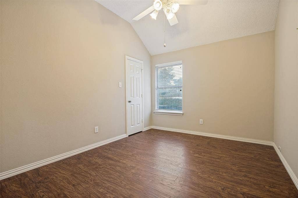 1909 Blackfoot Trail, Mesquite, TX 75149 Room featuring vaulted ceilings, wood-finish flooring, a ceiling fan with integrated lighting, and a single-panel interior door
