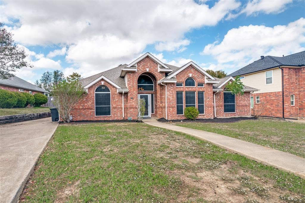 1909 Blackfoot Trail, Mesquite, TX 75149 Brick exterior featuring a gabled roofline, arched window accents, and a covered entryway