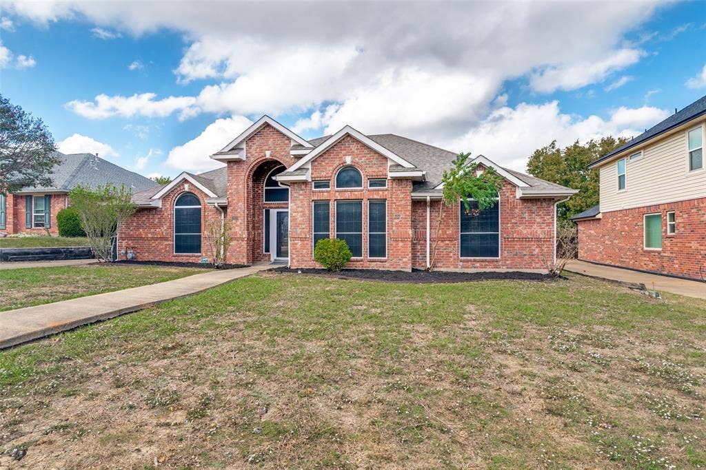 1909 Blackfoot Trail, Mesquite, TX 75149 Brick exterior featuring a gabled roofline, arched window detailing, and a prominent covered entryway